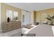 Neutral bedroom with a dresser, large mirror and sitting stool near the foot of the bed at 155 Annabelle Branch Ln, Apex, NC 27523