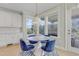 Charming dining area with a round table, blue velvet chairs, and bright windows at 155 Annabelle Branch Ln, Apex, NC 27523