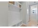 Hallway drop zone offers storage with baskets and hooks, next to a door with natural light at 155 Annabelle Branch Ln, Apex, NC 27523