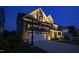 Beautiful home exterior at night featuring stone accents, a two-car garage, and professional landscaping at 155 Annabelle Branch Ln, Apex, NC 27523