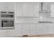 Bright kitchen with stainless steel double oven, white cabinets and subway tile backsplash at 155 Annabelle Branch Ln, Apex, NC 27523