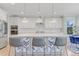 Bright kitchen with white cabinets, oversized island with seating and modern pendant lighting at 155 Annabelle Branch Ln, Apex, NC 27523