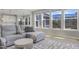 Bright living room features large windows overlooking a screened in porch and gray furniture at 155 Annabelle Branch Ln, Apex, NC 27523