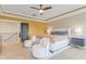 Well-lit main bedroom featuring light wood floors, accent wall, seating, and a comfortable queen-sized bed at 155 Annabelle Branch Ln, Apex, NC 27523
