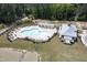 Aerial view of a uniquely shaped pool with plenty of seating and a community center at 155 Annabelle Branch Ln, Apex, NC 27523