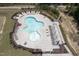 Aerial view of a uniquely shaped pool with plenty of seating and a shaded pergola at 155 Annabelle Branch Ln, Apex, NC 27523