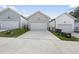 View of three detached garages with a driveway and landscaping at 1641 Glazebrook Dr, Wake Forest, NC 27587