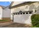 Attached two car garage door with decorative windows on a light yellow home at 17 Nicklaus Way, Clayton, NC 27520