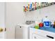 Functional laundry room equipped with a washer and dryer, and overhead shelving at 17 Nicklaus Way, Clayton, NC 27520