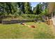 Spacious backyard with a grassy area, a deck, and a brick retaining wall at 2003 Wa Wa Ave, Durham, NC 27707