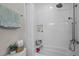 Well-lit bathroom featuring a tiled shower-tub, a rainfall shower head, and storage at 2003 Wa Wa Ave, Durham, NC 27707