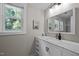 Bright bathroom with a white vanity, marble countertop, and large mirror at 2003 Wa Wa Ave, Durham, NC 27707