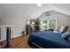 Bedroom with a desk, built-in bookshelves, hardwood floors, and a comfortable reading chair at 2003 Wa Wa Ave, Durham, NC 27707