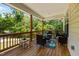 Inviting covered porch furnished with outdoor seating and play area surrounded by lush greenery at 2003 Wa Wa Ave, Durham, NC 27707