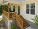 A charming home featuring a welcoming porch, wooden stairs, and an installed electric vehicle charger at 2003 Wa Wa Ave, Durham, NC 27707