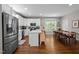 Modern kitchen with stainless steel appliances, island, and an adjacent dining area with seating at 2003 Wa Wa Ave, Durham, NC 27707