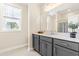 Bright bathroom with a modern vanity, a large mirror, and a view of outside at 2014 Anna Lilley Dr, Fuquay Varina, NC 27526