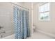 Clean bathroom features a tub/shower combination with a stylish blue patterned curtain at 2014 Anna Lilley Dr, Fuquay Varina, NC 27526