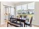 Bright dining area features a modern table with chairs, bench, and large windows overlooking the backyard at 2014 Anna Lilley Dr, Fuquay Varina, NC 27526