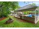 Outdoor living space including a pool, covered kitchen, fire pit, and lush landscaping at 204 Random Ln, Burlington, NC 27215