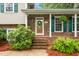 Charming brick home with a welcoming front door, green shutters, and well-manicured landscaping at 204 Random Ln, Burlington, NC 27215