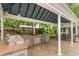 Covered outdoor kitchen with a grill, sink, and dining area, perfect for entertaining guests at 204 Random Ln, Burlington, NC 27215