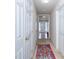 Hallway with multiple doors and a decorative pink, red and blue rug on the floor at 216 Ruby Walk Dr, Morrisville, NC 27560