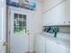 Functional laundry room with white cabinets, washer, dryer, and access to the backyard at 216 Ruby Walk Dr, Morrisville, NC 27560