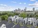 An aerial view of contemporary homes with sleek designs, featuring expansive windows and stylish exteriors against the city skyline at 221 Woodsborough Pl, Raleigh, NC 27601