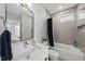 Tastefully-designed bathroom features white fixtures, a tiled shower, and modern lighting at 221 Woodsborough Pl, Raleigh, NC 27601