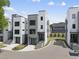 Modern townhome with gray and white facade, glass garage door, manicured lawn and blue sky at 221 Woodsborough Pl, Raleigh, NC 27601
