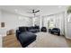 Bright living room with a comfortable blue sofa, ceiling fan, and natural light from surrounding windows at 221 Woodsborough Pl, Raleigh, NC 27601