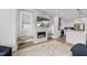 Open-concept kitchen and living area with a cozy fireplace and TV at 221 Woodsborough Pl, Raleigh, NC 27601