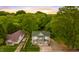 Aerial view of home showcasing lush greenery, green roof, and a tranquil, private setting at 223 Hall Ave, Burlington, NC 27217