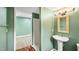 Bathroom featuring a pedestal sink, framed mirror, updated lighting, and a shower stall at 223 Hall Ave, Burlington, NC 27217