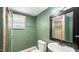 Bathroom featuring tile shower, toilet, sink, vanity and a framed mirror at 223 Hall Ave, Burlington, NC 27217