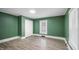 Bedroom with wood-look floors, neutral walls, and good natural light from a large window at 223 Hall Ave, Burlington, NC 27217