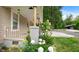 Charming front porch adorned with lush flowerbeds and decorative columns at 223 Hall Ave, Burlington, NC 27217