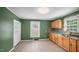 Bright kitchen with tile floors, wood cabinets, granite countertops, and stainless steel sink at 223 Hall Ave, Burlington, NC 27217