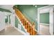 Wooden staircase with white trim, complemented by green walls, providing access to the upper level at 223 Hall Ave, Burlington, NC 27217