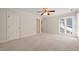 Spacious bedroom with neutral carpeting, ceiling fan, large window, and ample closet space at 2303 Upper Oaks Way, Raleigh, NC 27615