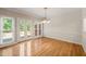 Bright dining area with wood floors, glass doors to the deck, and decorative chandelier at 2303 Upper Oaks Way, Raleigh, NC 27615