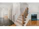 Inviting entryway featuring a staircase with decorative railing, fireplace and hardwood floors at 2303 Upper Oaks Way, Raleigh, NC 27615