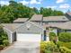 Charming home featuring a pristine white garage door, complemented by lush landscaping and mature trees at 2303 Upper Oaks Way, Raleigh, NC 27615