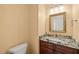 Charming powder room featuring granite countertop, decorative mirror, and ample lighting at 2303 Upper Oaks Way, Raleigh, NC 27615
