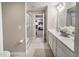 Bright bathroom featuring a double sink vanity, decorative accents, tile flooring, and a glass-enclosed shower at 238 Oak Meadow Ln, Angier, NC 27501