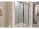 Tiled shower with glass enclosure in a neutral-toned bathroom with a glimpse into the bedroom at 238 Oak Meadow Ln, Angier, NC 27501