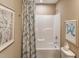 Cozy bathroom featuring a tub-shower combination with a decorative shower curtain and neutral wall art at 238 Oak Meadow Ln, Angier, NC 27501