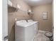 Well-lit laundry room with white washer and dryer, wire shelf and a dog bed at 238 Oak Meadow Ln, Angier, NC 27501