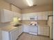 Functional kitchen features white cabinets, appliances, and ample counter space at 2521 Friedland Pl # 301, Raleigh, NC 27617